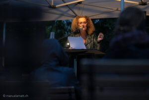Rapperswil, Badi Stampf, Stadtbibliothek Rapperswil-Jona führt den Anlass „Literatur geht baden“ mit Autorin Sabine Haupt durch, begleitet wird die Lesung von Musik eines Teils der interkulturellen Gruppe Ssassa, Christian Fotsch und Franziska Heusser, 31.8.23, Foto: Manuela Matt, manuelamatt.ch